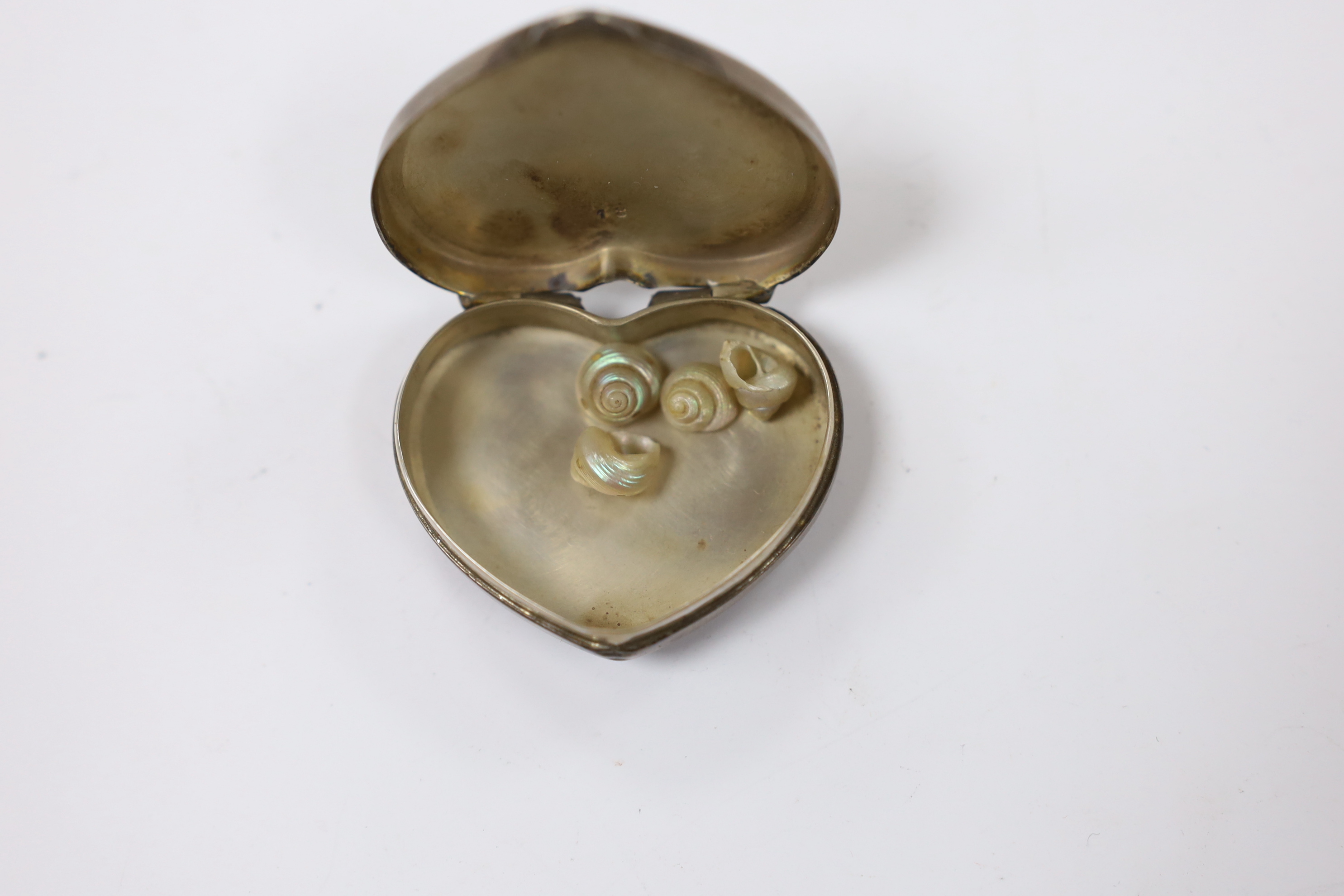 A 20th century Cartier sterling and enamel heart shaped pill box, decorated with flower heads, width 41mm.
